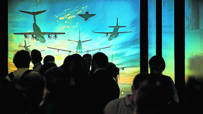 El público asistente a la inauguración de la muestra, delante de una de las imágenes de los aviones actuales de Airbus.