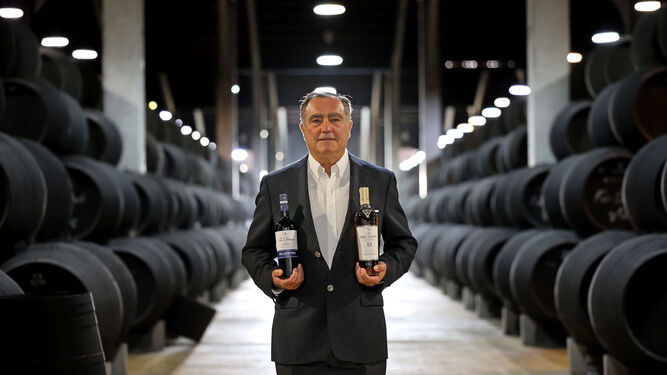 José Ramón Estévez posa con una botella de Macallan y otra de Valdespino junto a las andanas de botas en las que se cría la marca más emblemática de los vinos del grupo bodeguero jerezano.